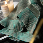 Tissu décoratif vert avec motifs géométriques élégant pour intérieur moderne, ambiance chaleureuse avec bougie allumée à côté, parfait pour rideaux ou décoration maison. Idéal pour créer une atmosphère raffinée dans chaque pièce.