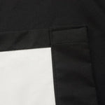 Housse de coussin carrée noire et blanche avec coutures visibles pour un design moderne et élégant, accent idéal pour la décoration intérieure contemporaine.