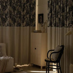 Rideaux élégants à motif floral noir et blanc dans un salon moderne, accentuant une ambiance chaleureuse et accueillante. Parfaits pour ajouter une touche de sophistication et de style à tout intérieur.