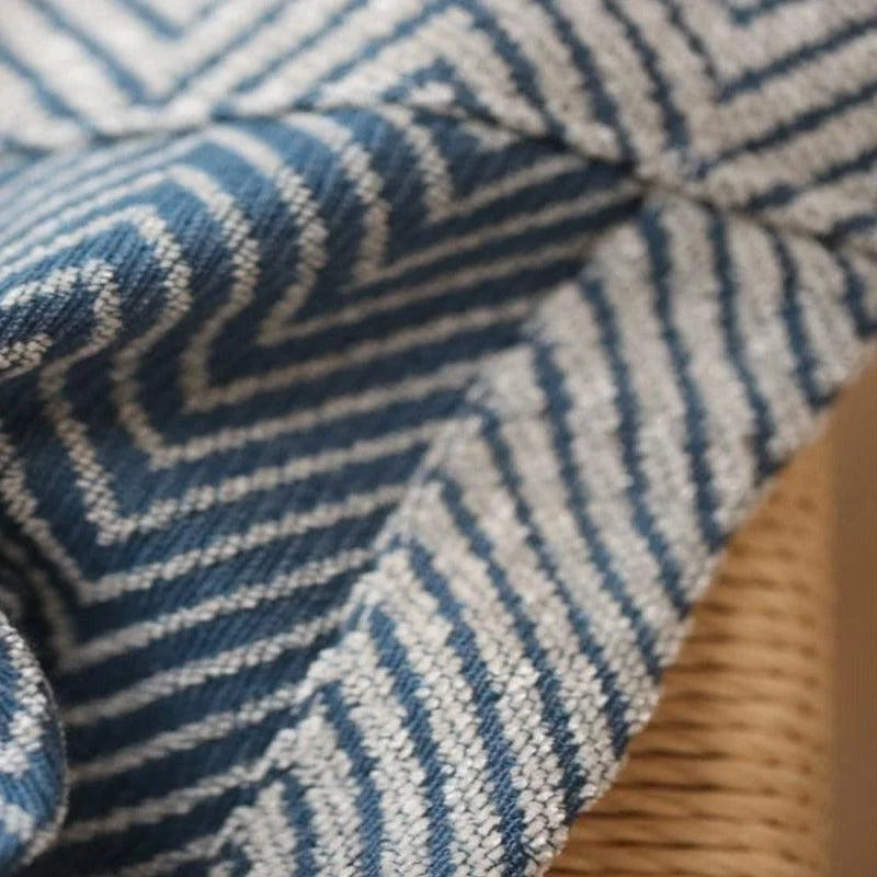 Dessin géométrique bleu et blanc d'un tissu plié, style moderne, idéal pour la décoration intérieure et le confort. Parfait pour ajouter une touche élégante et raffinée à n'importe quel espace de vie.