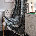Plaid décoratif à motifs floraux en bleu et blanc, ornant un intérieur élégant avec un fauteuil capitonné et une commode sculptée. Accessoire parfait pour ajouter une touche de charme et de confort à votre salon.