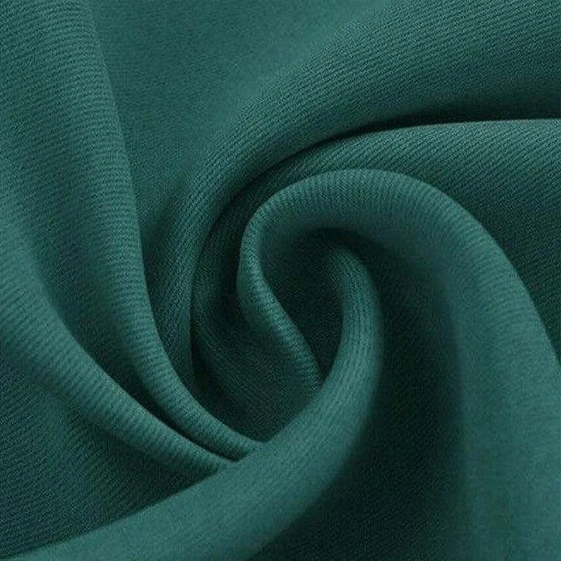 Texture élégante de tissu avec drapé fluide vert émeraude, idéal pour la mode et la décoration intérieure raffinée.