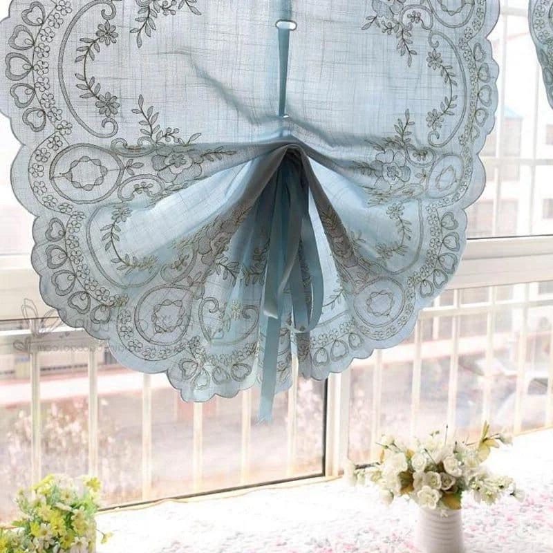 Jolie brise-bise décorative bleue avec motifs floraux raffinés, idéale pour embellir une fenêtre. Accrochée devant une baie vitrée, elle laisse entrer la lumière naturelle tout en ajoutant une touche élégante à votre intérieur. Parfaite pour des espaces comme la cuisine ou le salon, elle apporte charme et sophistication à votre décoration intérieure.