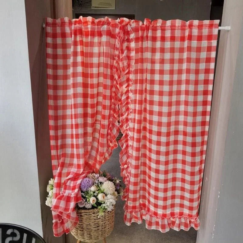 Rideau à carreaux rouges et blancs avec volants, parfait pour ajouter une touche rétro et chaleureuse à votre intérieur. Idéal pour la cuisine ou espace détente. Panier décoratif de fleurs en bas pour accentuer l'élégance et la douceur de l'ensemble. Solution décorative pour un environnement accueillant et charmant.