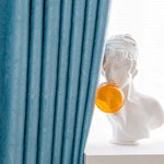 Rideaux occultants bleus élégants pour salon moderne, mettant en valeur une décoration intérieure sophistiquée avec une statue artistique blanche et une bulle colorée. Idéal pour créer une ambiance chic et raffinée dans votre espace de vie.