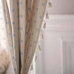 Rideau élégant beige à motifs floraux bleus, agrémenté de franges décoratives, idéal pour ajouter une touche raffinée à votre intérieur. Parfait pour les salons ou chambres, apportant une atmosphère chaleureuse et accueillante.