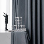 Rideaux élégants de couleur grise, parfaits pour ajouter une touche moderne et sophistiquée à votre intérieur. Accessoirisés avec une sculpture décorative et un livre posé sur une table, ces rideaux créent une ambiance chic et contemporaine dans n'importe quelle pièce de la maison.
