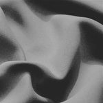 Texture élégante et fluide d'un tissu gris, parfaite pour la mode et la décoration intérieure, reflétant le raffinement et la modernité.