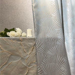 Rideaux élégants avec motifs géométriques modernes pour décoration intérieure. Ambiance chic et raffinée avec fond de table assorti. Idéal pour salon ou chambre, apportant une touche de luxe à votre espace. Accessoires de décoration comme fleurs blanches et chandelle pour une atmosphère chaleureuse et accueillante.