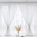 Rideaux translucides blancs élégants pour salon moderne, idéal pour laisser entrer la lumière naturelle tout en préservant l'intimité. Design contemporain avec attaches décoratives, parfaits pour créer une ambiance lumineuse et apaisante dans votre espace de vie. Accessoire déco indispensable pour rehausser le style de votre intérieur.
