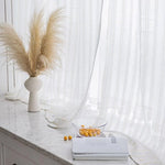 Vase décoratif minimaliste avec herbes pampas naturelles sur un rebord de fenêtre lumineux, aux côtés de rideaux élégants et d'une table en marbre. Transformez votre intérieur avec cet accent moderne et épuré qui s’intègre parfaitement dans un salon ou une chambre. Idéal pour apporter une touche de sophistication et de naturel à votre espace de vie.