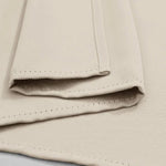 Serviette beige pliée avec coutures décoratives, parfaite pour apporter une touche élégante à votre salle de bain ou cuisine. Accessoire pratique et sophistiqué pour la maison.