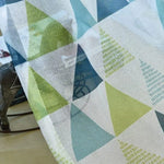 Image d'un tissu aux motifs géométriques colorés en vert et bleu, idéal pour apporter une touche moderne à votre intérieur. Design contemporain parfait pour décoration de maison, rideaux ou accessoires textiles tendance.