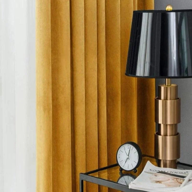 Lampe élégante avec abat-jour noir sur une table en verre, accompagnée de rideaux dorés et d'une horloge moderne. Parfaite pour ajouter une touche chic à votre intérieur.