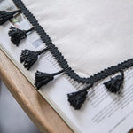 Image d’un chemin de table élégant avec bordure à franges noires, idéal pour ajouter une touche de sophistication à votre décoration intérieure. Il apporte une ambiance chic et moderne à votre salle à manger ou salon, parfait pour des occasions spéciales ou une utilisation quotidienne.