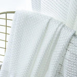 Voilage blanc avec motif géométrique sur chaise, idéal pour une décoration intérieure élégante et lumineuse. Parfait pour laisser passer la lumière tout en préservant l'intimité. Ambiance moderne et épurée.