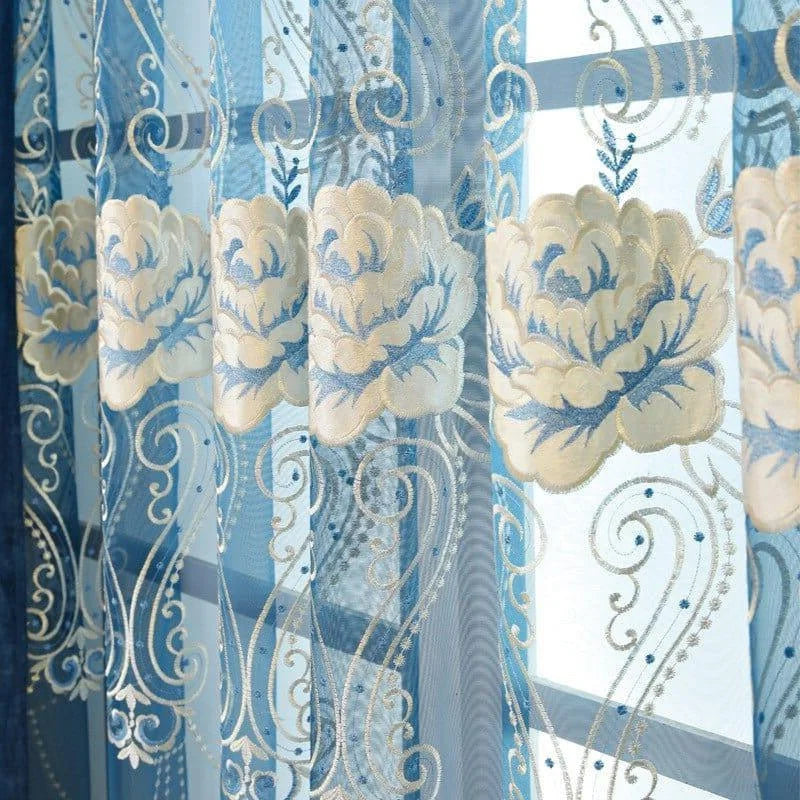 Rideau décoratif avec motifs floraux en bleu et blanc, idéal pour un intérieur élégant et sophistiqué. Ce voilage ajoute une touche artistique à votre salon ou chambre, tout en permettant à la lumière naturelle d'éclairer votre espace avec douceur. Parfait pour ceux qui souhaitent enrichir leur décoration intérieure avec des détails raffinés.