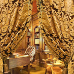 Rideaux élégants pour un bureau luxueux avec un design classique. Idéaux pour ajouter une touche sophistiquée à votre espace de travail, ces rideaux à motifs s’harmonisent parfaitement avec des meubles en bois richement décorés et des étagères remplies de livres anciens. Créez une atmosphère chaleureuse et accueillante dans votre bureau avec ces rideaux raffinés.