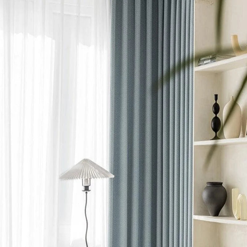 Rideaux élégants bleus et blancs dans un salon moderne avec une lampe design. Bibliothèque décorative avec vases géométriques noirs et blancs. Décoration intérieure contemporaine et apaisante.