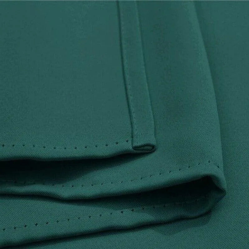 Vue rapprochée d'un tissu vert avec des détails de couture soignés, idéal pour des projets de décoration intérieure ou de confection vestimentaire raffinée. Ce textile sophistiqué offre une couleur riche et élégante pour rehausser n'importe quel espace ou tenue.