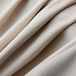 Drapé élégant de tissu beige avec motif subtil en chevrons, idéal pour la décoration intérieure et la confection de vêtements sophistiqués. Design raffiné et moderne, parfait pour ajouter une touche de charme à tout espace.