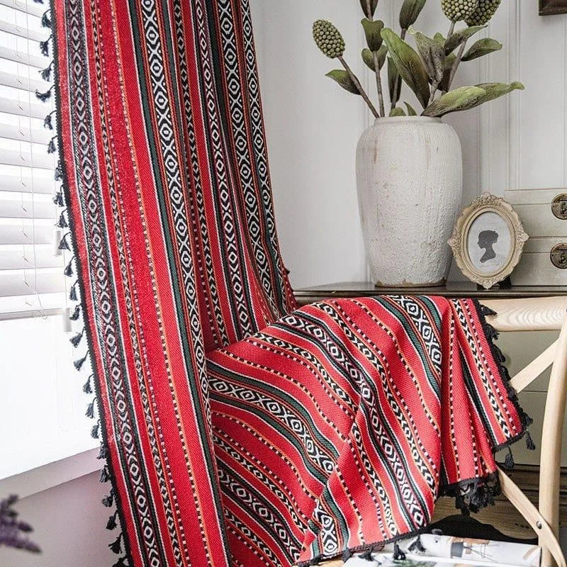 Couverture décorative à motifs ethniques rouges, ornée de franges noires. Elle ajoute une touche chaleureuse et stylée à votre intérieur. Idéale pour rehausser un canapé ou un fauteuil avec élégance. Accessoire parfait pour un salon moderne ou une chambre cosy.