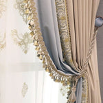 Rideau élégant avec broderies dorées et détails frangés. Idéal pour apporter une touche sophistiquée à votre intérieur. Accessoire parfait pour optimiser la décoration de votre salon ou chambre. Élément décoratif chic avec nuances beige et bleu, accentuant une ambiance classique et raffinée.