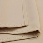 Gros plan sur des serviettes de table beige avec de fines coutures, parfaites pour une décoration élégante de votre salle à manger. Accessoire indispensable pour les réceptions et dîners formels.