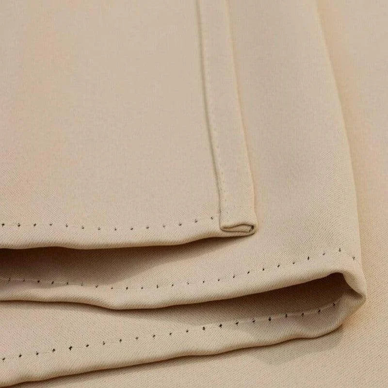 Gros plan sur des serviettes de table beige avec de fines coutures, parfaites pour une décoration élégante de votre salle à manger. Accessoire indispensable pour les réceptions et dîners formels.