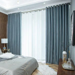 Rideaux élégants de couleur bleue dans une chambre moderne, ajoutant une touche sophistiquée à la décoration intérieure. Idéal pour contrôler la luminosité et améliorer l'ambiance chaleureuse de la pièce. Convient parfaitement pour une chambre à coucher contemporaine.