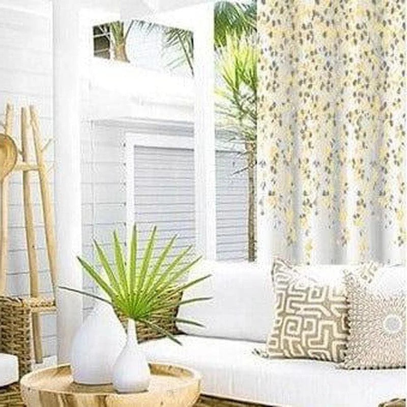 Salon extérieur moderne avec un élégant rideau floral. Canapé confortable décoré de coussins à motifs géométriques. Atmosphère lumineuse et naturelle avec des plantes vertes en pot, idéale pour la détente.