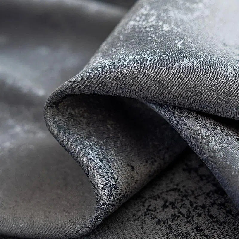 Image d'un tissu gris foncé avec un motif texturé, idéal pour la décoration intérieure moderne. Ce textile élégant ajoute une touche sophistiquée aux rideaux, coussins ou couvre-lit. Parfait pour un style contemporain et chic, ce textile se distingue par ses détails subtils et son fini raffiné. Choix idéal pour rehausser l'esthétique d'un salon ou d'une chambre.