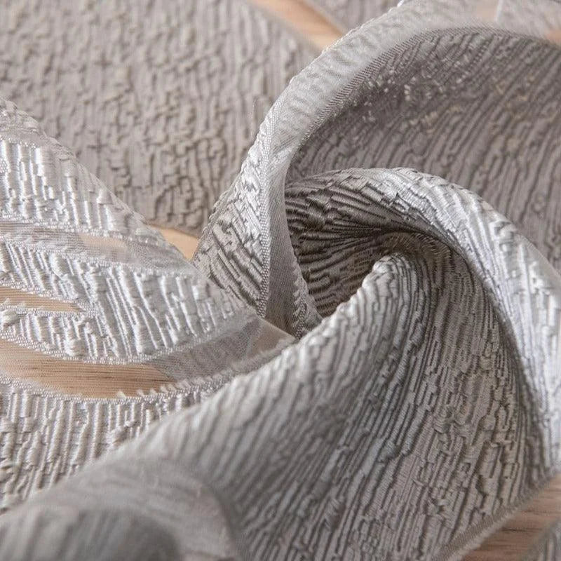 Drapé élégant de couleur gris clair avec un motif texturé sophistiqué, parfait pour la décoration intérieure contemporaine. Idéal pour apporter une touche chic et moderne à votre espace de vie.