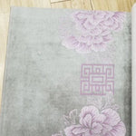 Image d'un rideau élégant en tissu gris avec un motif floral rose délicat et un design géométrique, idéal pour ajouter une touche raffinée et contemporaine à votre décoration intérieure. Ce rideau de haute qualité est parfait pour les salons modernes et les chambres à coucher, offrant une esthétique apaisante et sophistiquée.