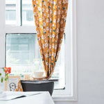 Rideau à motif floral vintage jaune dans une ambiance intérieure lumineuse, apportant une touche élégante et chaleureuse à la décoration de la maison. Parfait pour embellir votre salon ou chambre avec son design attrayant et ses motifs de fleurs. Découvrez comment un rideau bien choisi peut transformer la lumière naturelle et ajouter du charme à n'importe quelle pièce.