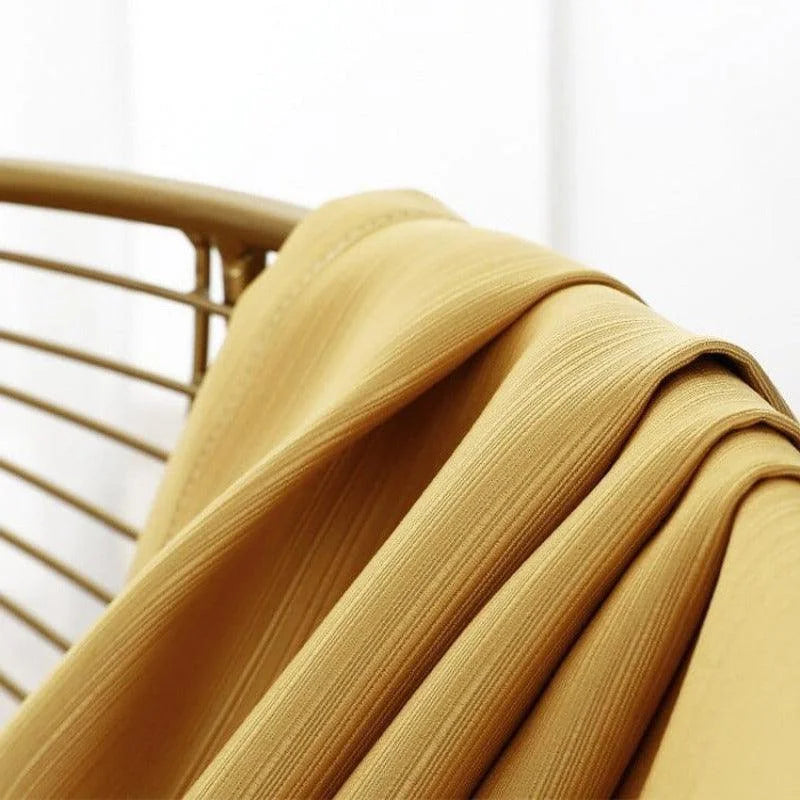 Textile jaune drapé sur une chaise dorée, idéal pour ajouter une touche chaleureuse et élégante à votre décoration intérieure. Découvrez ce tissu versatile, parfait pour la confection de rideaux ou d'accessoires maison, alliant style et fonctionnalité.