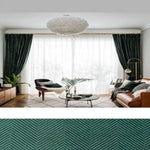 Salon moderne avec rideaux vert foncé habillant de grandes fenêtres, offrant une ambiance lumineuse et élégante. Canapé confortable agrémenté de coussins décoratifs, table basse design au centre, sur un tapis géométrique clair. Plantes d'intérieur ajoutant une touche naturelle et fraîche. Lustre élégant suspendu, complétant un style contemporain et accueillant.