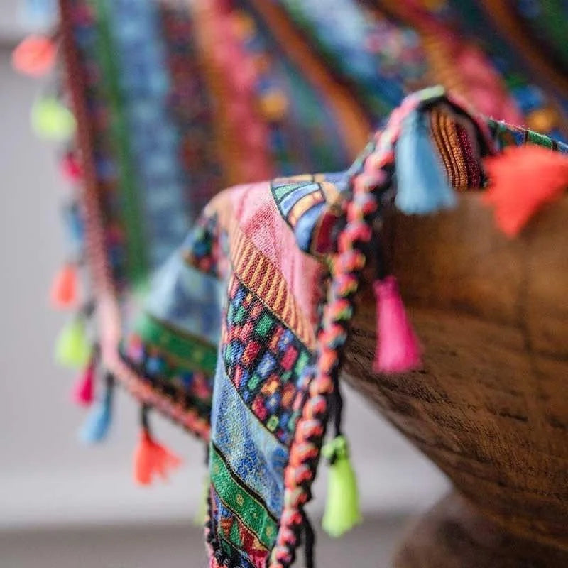 Écharpe multicolore bohème avec motifs géométriques et pompons colorés, accessoire tendance pour ajouter une touche vibrante à votre tenue. Parfaite pour un look casual ou chic, elle apporte chaleur et style en toute saison. Véritable must-have pour les amoureux de mode.