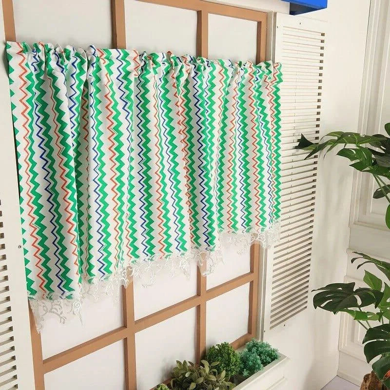 Rideau coloré à motifs zigzag installée dans une décoration intérieure moderne, parfaite pour ajouter une touche vibrante et élégante à votre espace. Ces rideaux uniques disposent d'un design multicolore, intégrant des teintes vertes, orange et bleues, idéal pour illuminer une pièce. Complément idéal pour un aménagement intérieur tendance.
