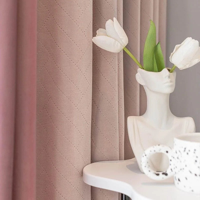 Vase décoratif moderne en forme de buste placé sur une table blanche, agrémenté de fleurs blanches élégantes, accompagné d'une tasse au design original, avec en arrière-plan de magnifiques rideaux beiges texturés. Idéal pour sublimer votre intérieur avec une touche artistique et contemporaine.