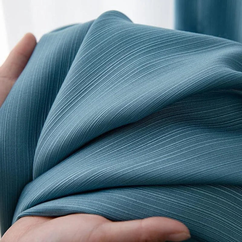 Tissu bleu plissé élégant et moderne, idéal pour la décoration intérieure ou la création de vêtements raffinés. Design texturé offrant un aspect visuel unique et attrayant, parfait pour ajouter une touche de style à tout projet créatif.