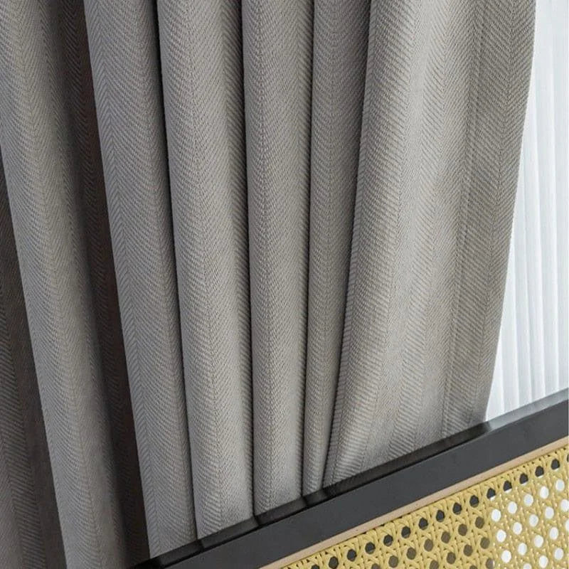Rideau élégant plié en accordéon avec une teinte grise, idéal pour une décoration intérieure moderne. Le design raffiné de ce rideau s'harmonise parfaitement avec divers styles d'ameublement, ajoutant une touche de sophistication à votre espace de vie. Le bas du rideau présente une finition unique qui accentue son aspect contemporain.