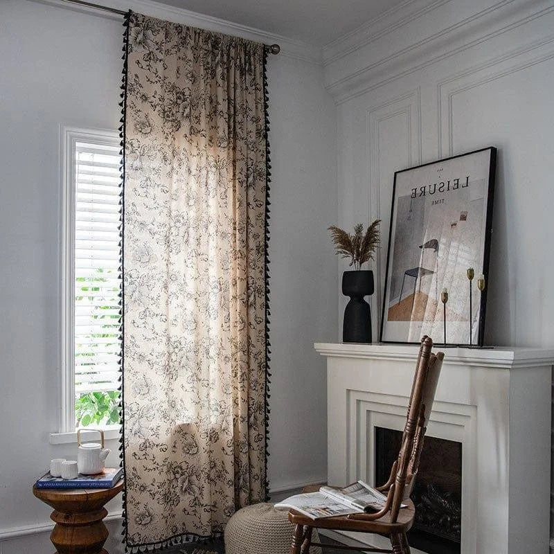 Rideau à motifs floraux ajoutant une touche d'élégance à un salon moderne avec cheminée. Décoration intérieure chic avec un mélange de textures et de couleurs neutres, idéal pour créer une ambiance chaleureuse et accueillante.