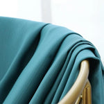 Drapé élégant de couleur bleu canard sur une chaise dorée, parfait pour rehausser la décoration intérieure avec style et sophistication. Idéal pour ajouter une touche moderne et chic à n'importe quelle pièce de la maison.