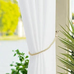 Embrasse rideau décoratif blanc avec embrasse corde élégante, parfait pour ajouter une touche raffinée à votre intérieur. Vue sur un espace extérieur verdoyant à travers une fenêtre. Accessoire idéal pour salons, chambres ou espaces de détente, apportant luminosité et élégance.