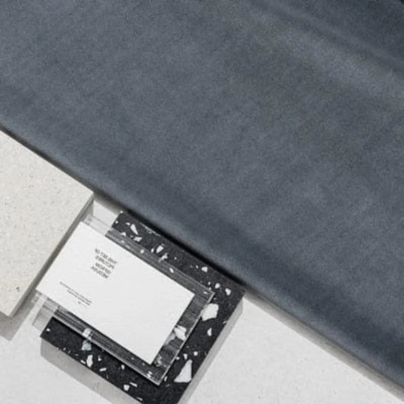 Tissu gris de haute qualité posé à côté de blocs design modernes en noir et blanc. Idéal pour les projets de décoration intérieure élégante et contemporaine, ce tissu s'harmonise parfaitement avec des accessoires minimalistes. Parfait pour les amateurs de styles épurés et sophistiqués.