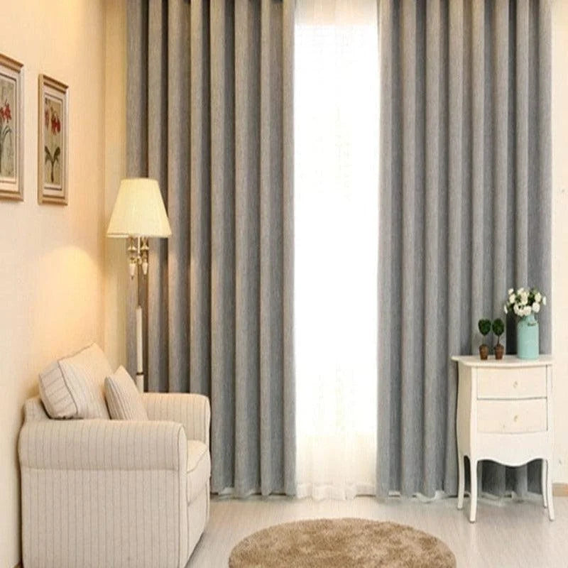 Rideaux occultants gris élégants pour un salon moderne, apportant une ambiance cosy et lumineuse. Parfaits pour offrir une touche de sophistication à votre décoration intérieure tout en contrôlant la luminosité. Ces rideaux s'intègrent aisément dans différents styles d'aménagement, augmentant le confort et l'intimité de votre espace de vie. Idéal pour une atmosphère chaleureuse et contemporaine.