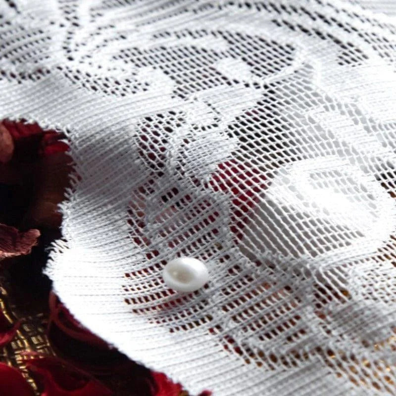 Détail d'un textile décoratif avec motif floral délicat et perle, idéal pour ajouter une touche élégante à votre décoration intérieure ou confectionner des accessoires de mode uniques.