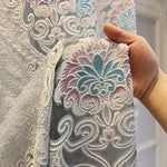 Rideau élégant avec motif floral en filigrane, accentué de nuances bleues et roses. Design classique et raffiné idéal pour embellir un salon ou une chambre. Parfait pour ajouter une touche de sophistication à votre décoration intérieure.