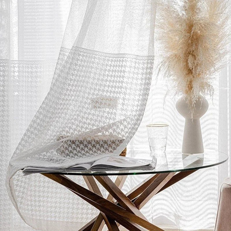 Voilage blanc élégant avec motif carreaux, idéal pour une ambiance lumineuse et moderne dans le salon. Ce rideau léger ajoute une touche décorative subtile tout en préservant l'intimité. Parfait pour accompagner une décoration contemporaine et un mobilier en bois design, créant une atmosphère chaleureuse et accueillante. Средена форме пампасной травы добавляет нотку естественности к оформлению окна.